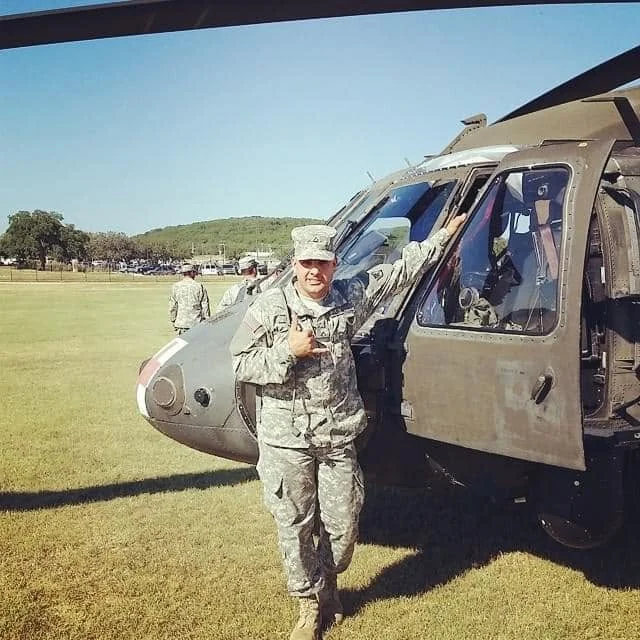 Daniel Costa in uniform beside a Black Hawk helicopter during his eight years in the U.S. Army