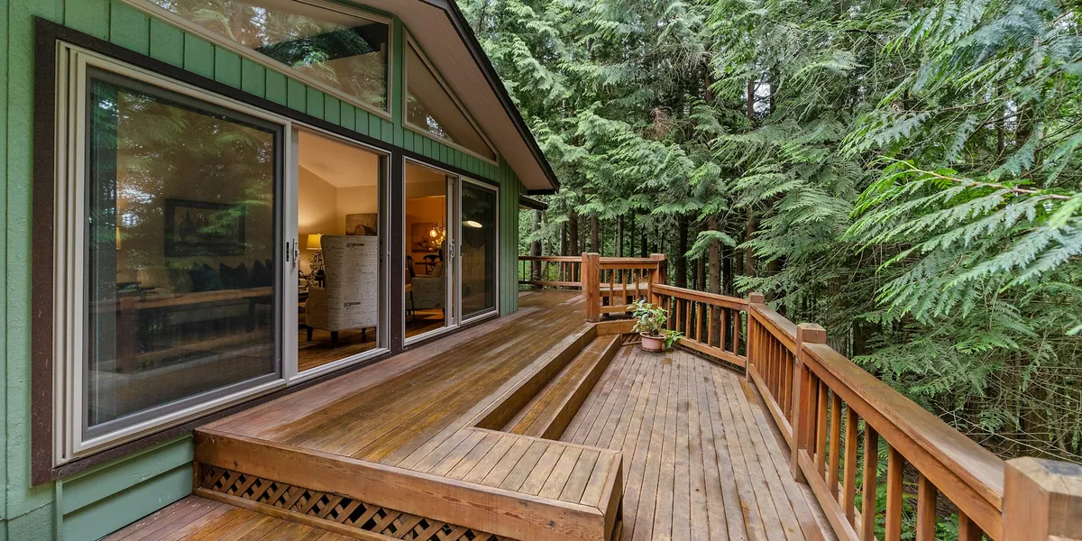 Clean wood deck with railings outside a home's sliding glass doors