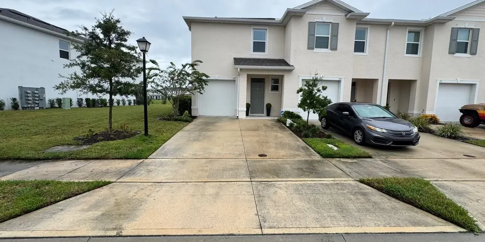 Before: townhome driveway with dark staining
