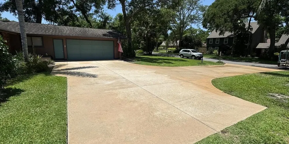 After: long concrete driveway with dark mildew, cleaned