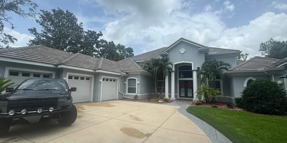 After: front of a stucco home and driveway, cleaned