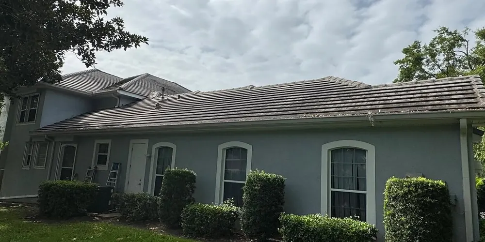 Before: side of a stucco home with a tile roof