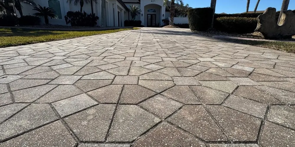 Before: large paver driveway with a geometric pattern