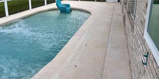 After: pool deck beside a brick wall, cleaned