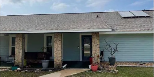After: home with a shingle roof and solar panels, cleaned