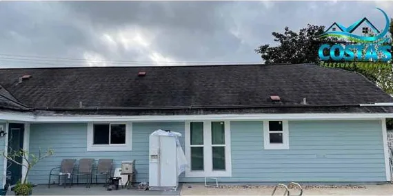Before: back of a home with a dark shingle roof
