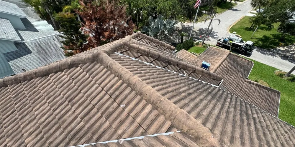 Before: terracotta tile roof darkened by algae