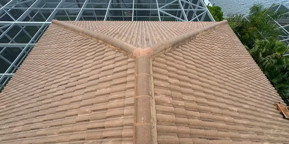 After: tile roof beside a pool enclosure, darkened by algae, cleaned