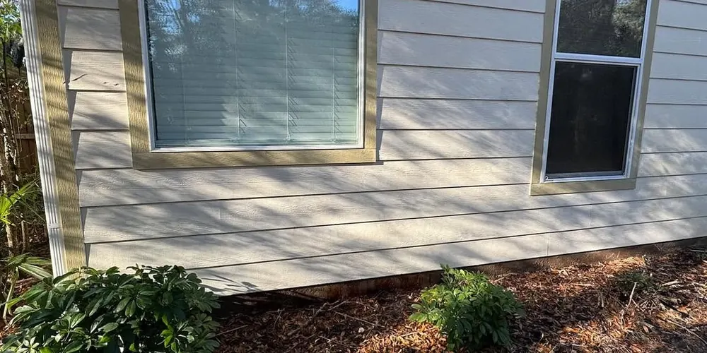 After: siding with a heavy orange rust stain below a window, cleaned
