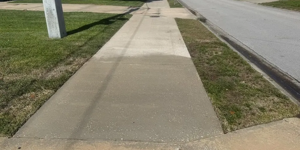 After: dark, mildewed sidewalk along a street, cleaned