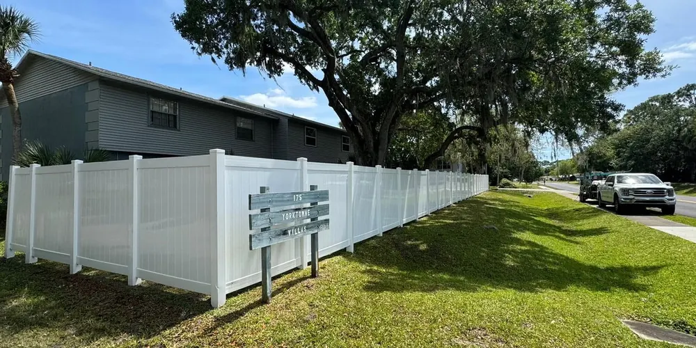 After: white vinyl fence streaked with green mildew, cleaned